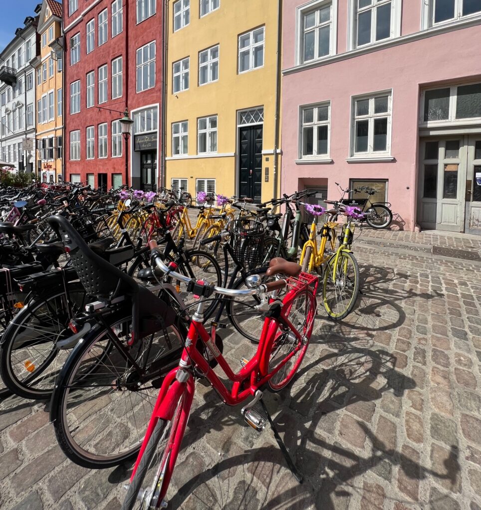 Polkupyöriä pysäköityinä kadulla värikkäiden talojen edessä Kööpenhaminan Nyhavnissa.